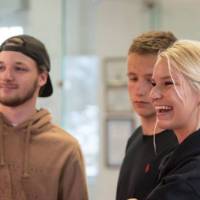 Three students laugh while reading a story